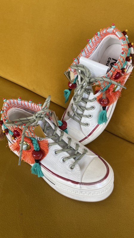 la basket mi haute de chez NANKU blanche avec ses pompons colorés 